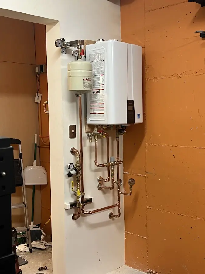 Plumbing technician inspecting water heater connections in Orinda
